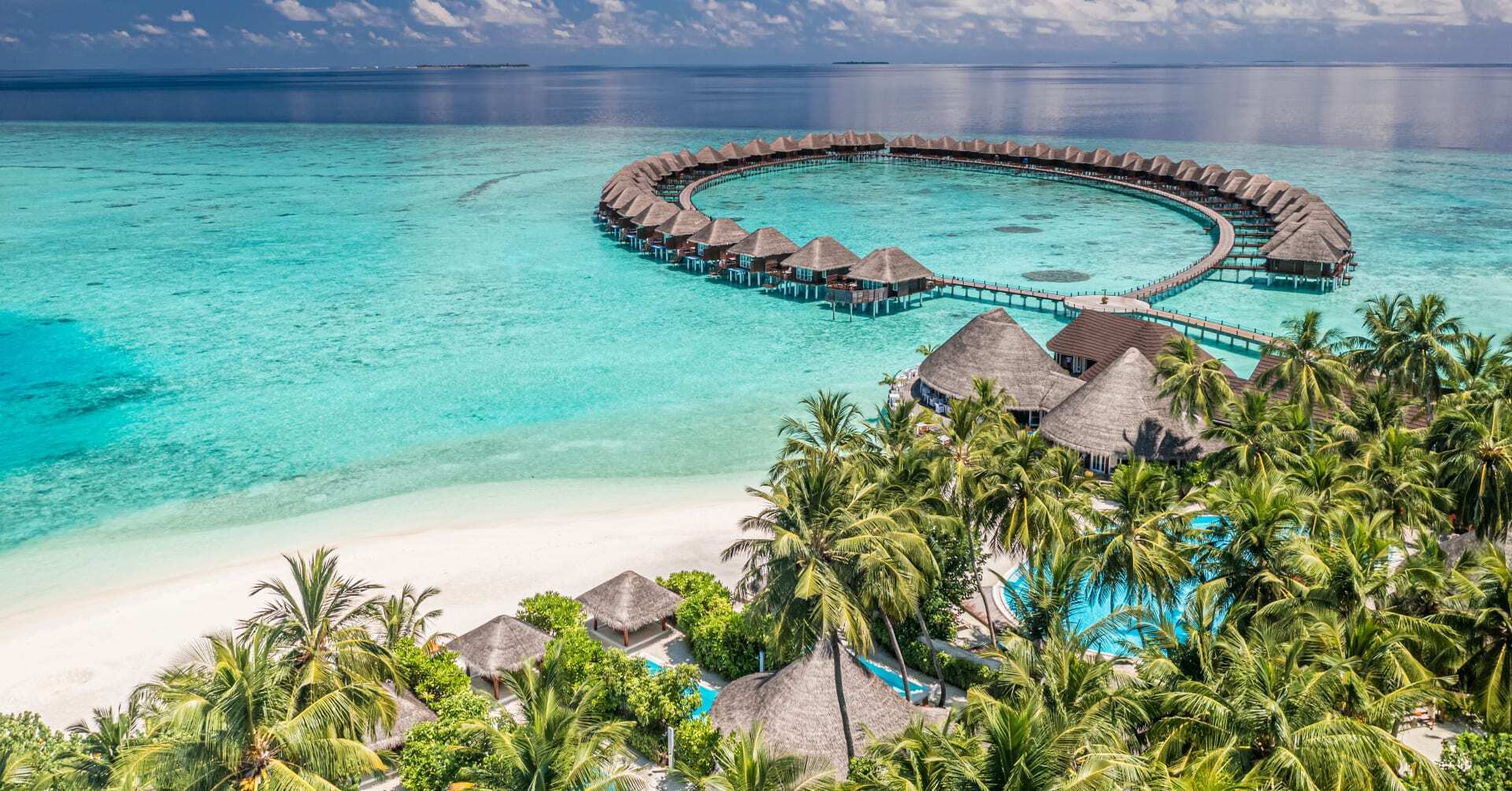 Maldives overwater bungalows with crystal clear turquoise lagoon and pristine white sand beach